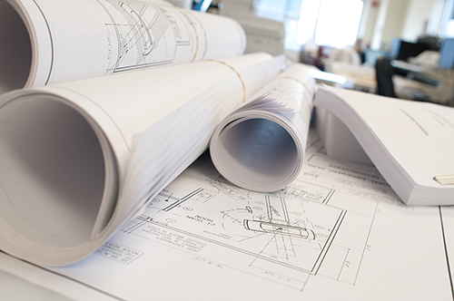 Photo of Rolled up Blueprints on Top of Architectural Drawings