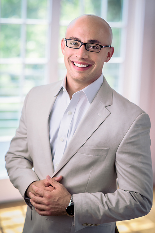 Professional headshot of a young real estate developer